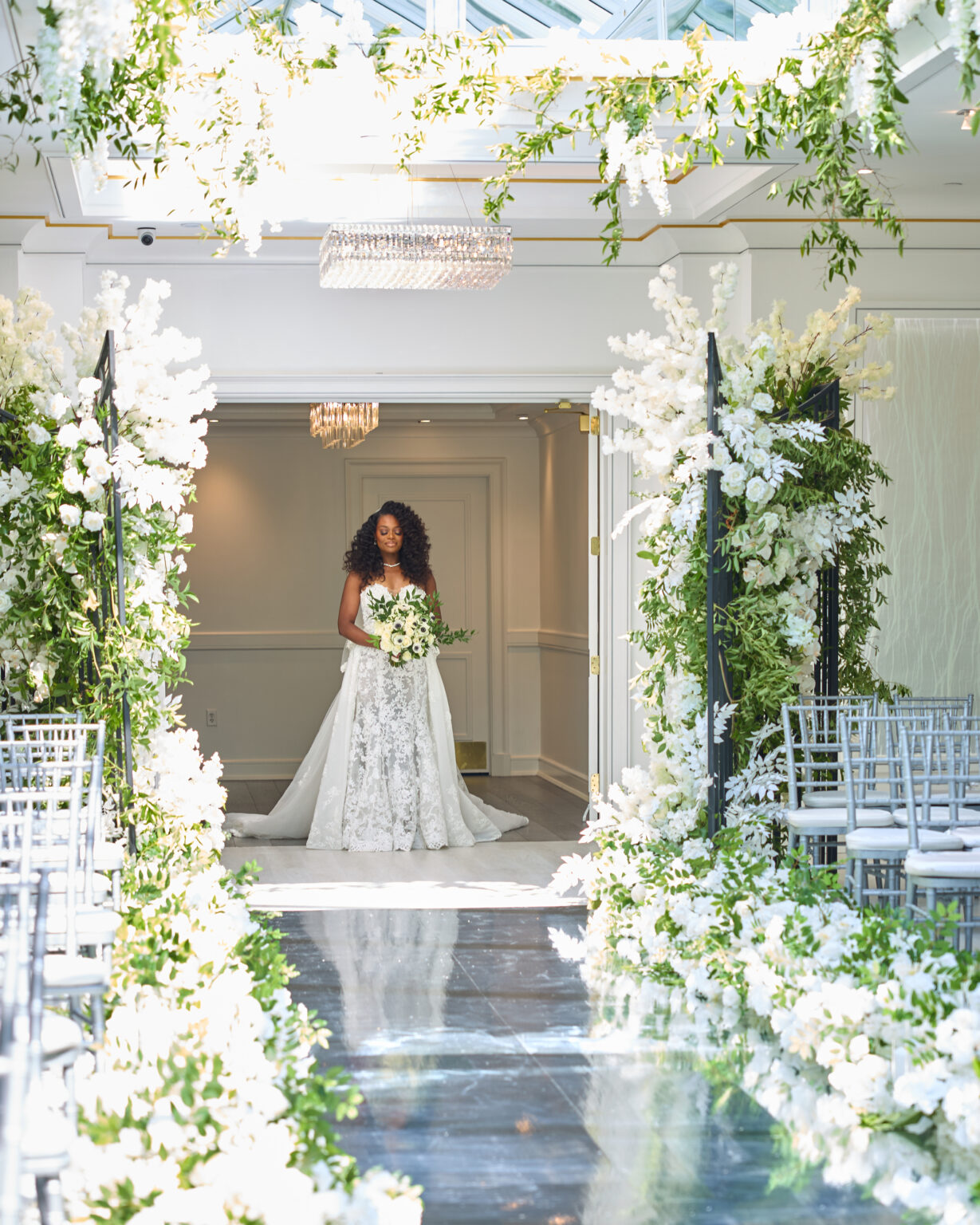 Bride walking down an aisle of white flowers