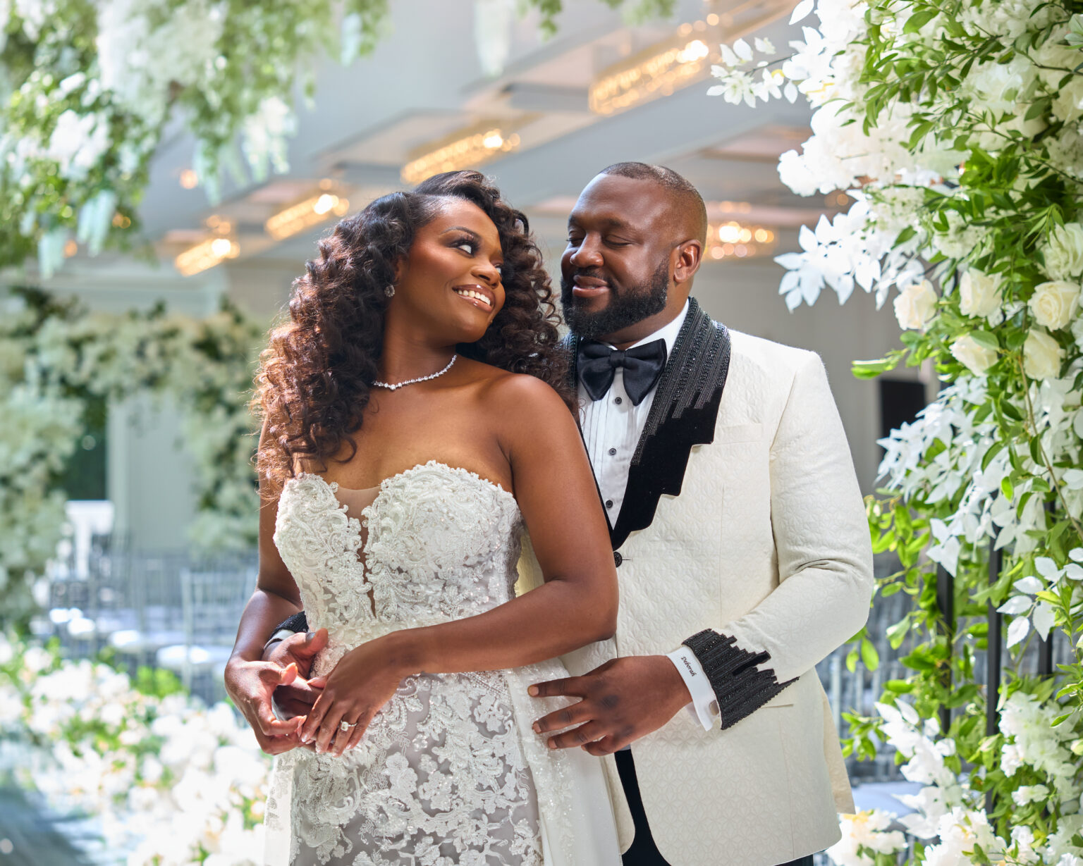 Bride and groom embracing among white florals